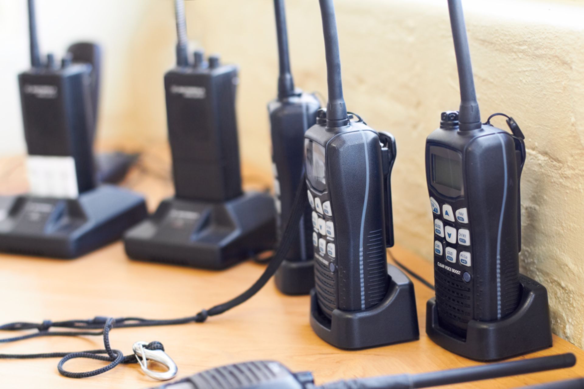 Several Black Two-way Radios Charging on a Table Near a Wall — Central Western Communications in Emerald, QLD