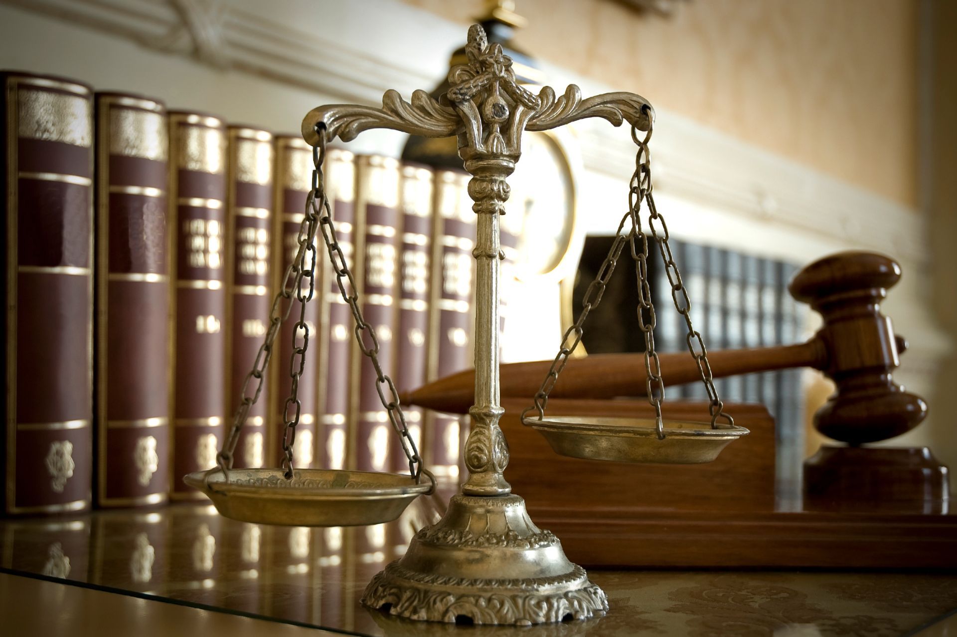 Scales of justice, books, and gavel on a shelf, symbolizing law and order.