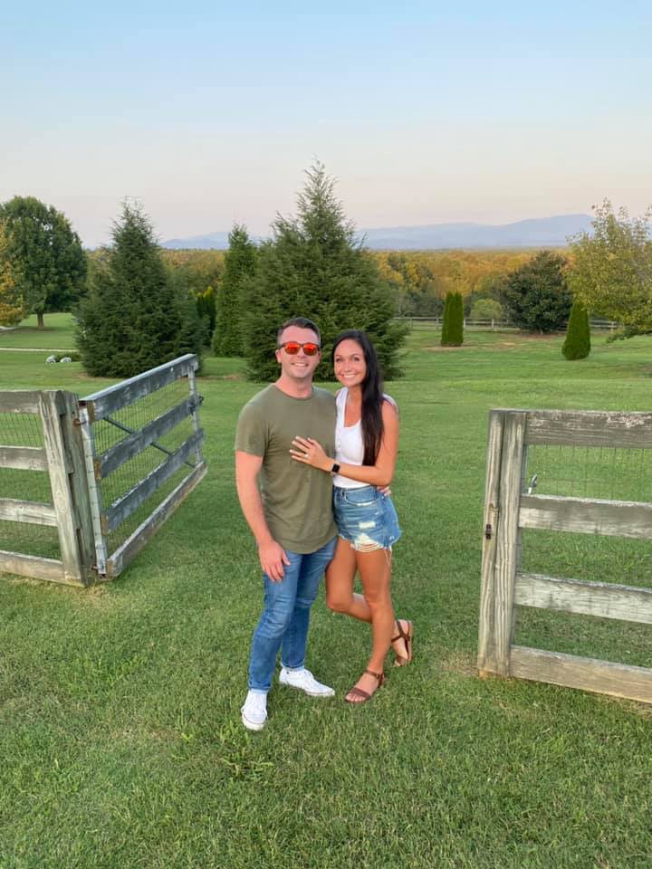 A man and a woman are standing next to each other in a field.