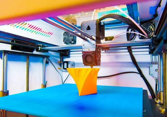 Orange part being printed on a commercial 3D printer