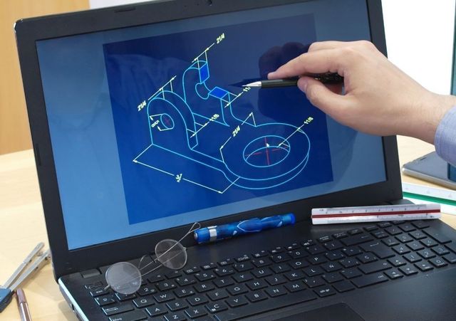 Designer drawing a 3D CAD model on a laptop