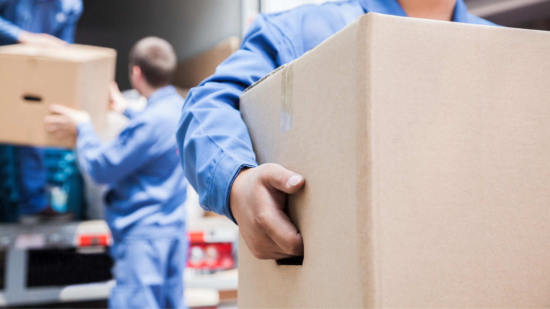 A man is holding a cardboard box in his hand.
