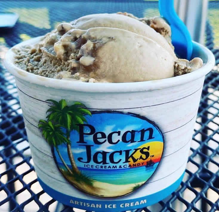 A cup of pecan jacks ice cream with a blue spoon