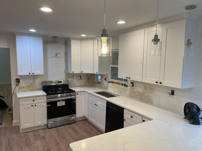 White kitchen remodel with new cabinets, countertops, and appliances.