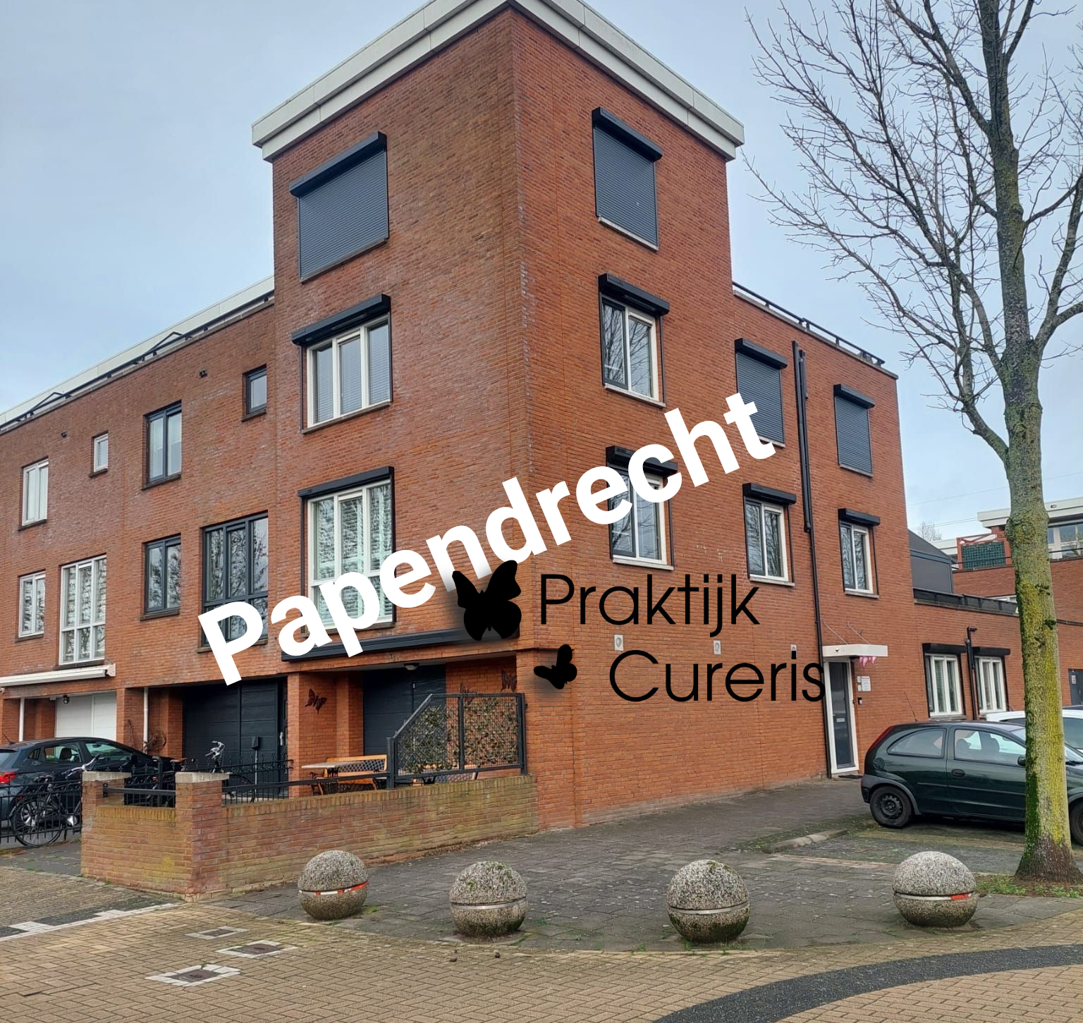 Straatbeeld van bakstenen gebouwen met auto's die langs de straat geparkeerd staan. De tekst erboven luidt 
