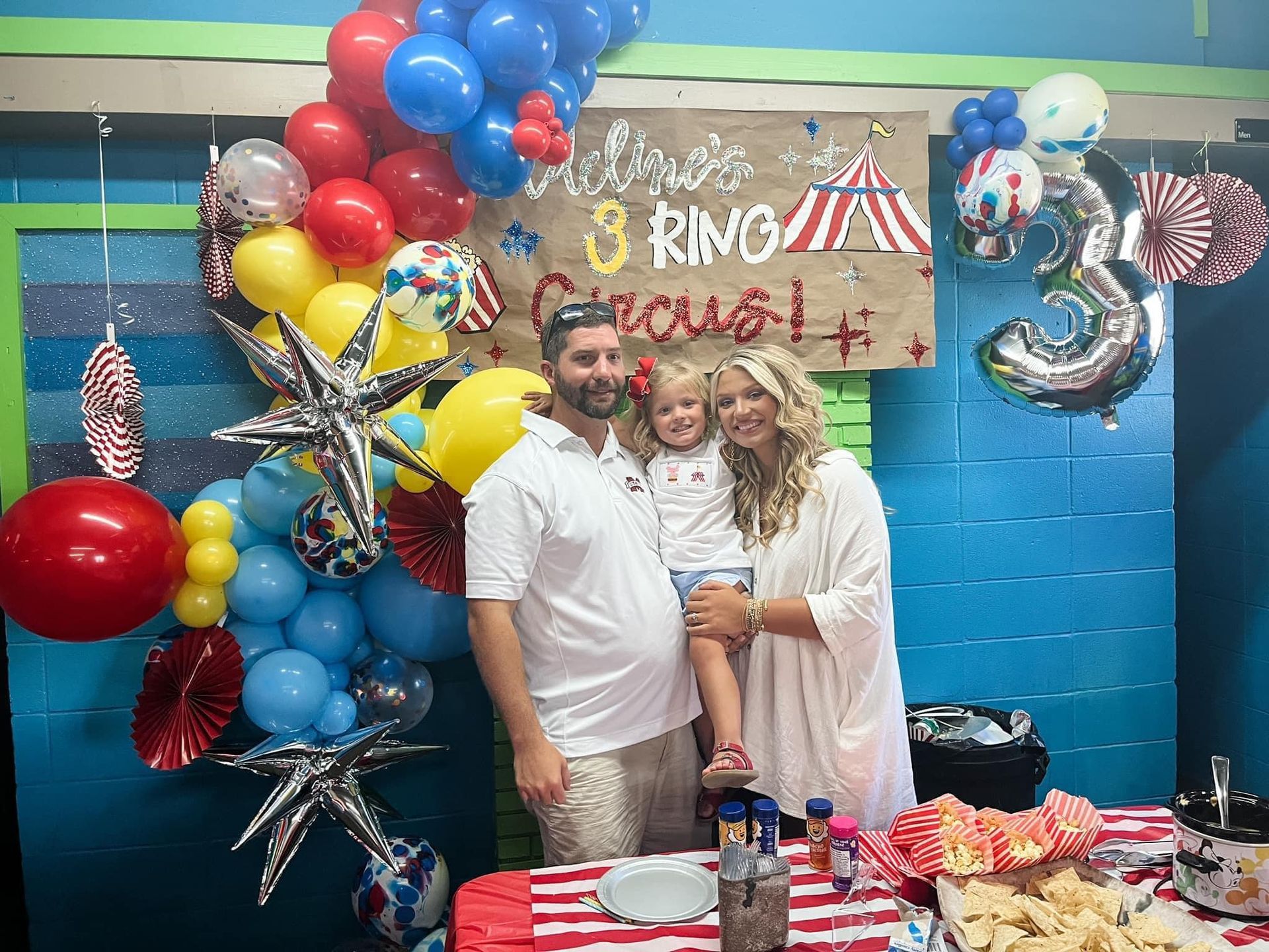 A family is posing for a picture at a birthday party.