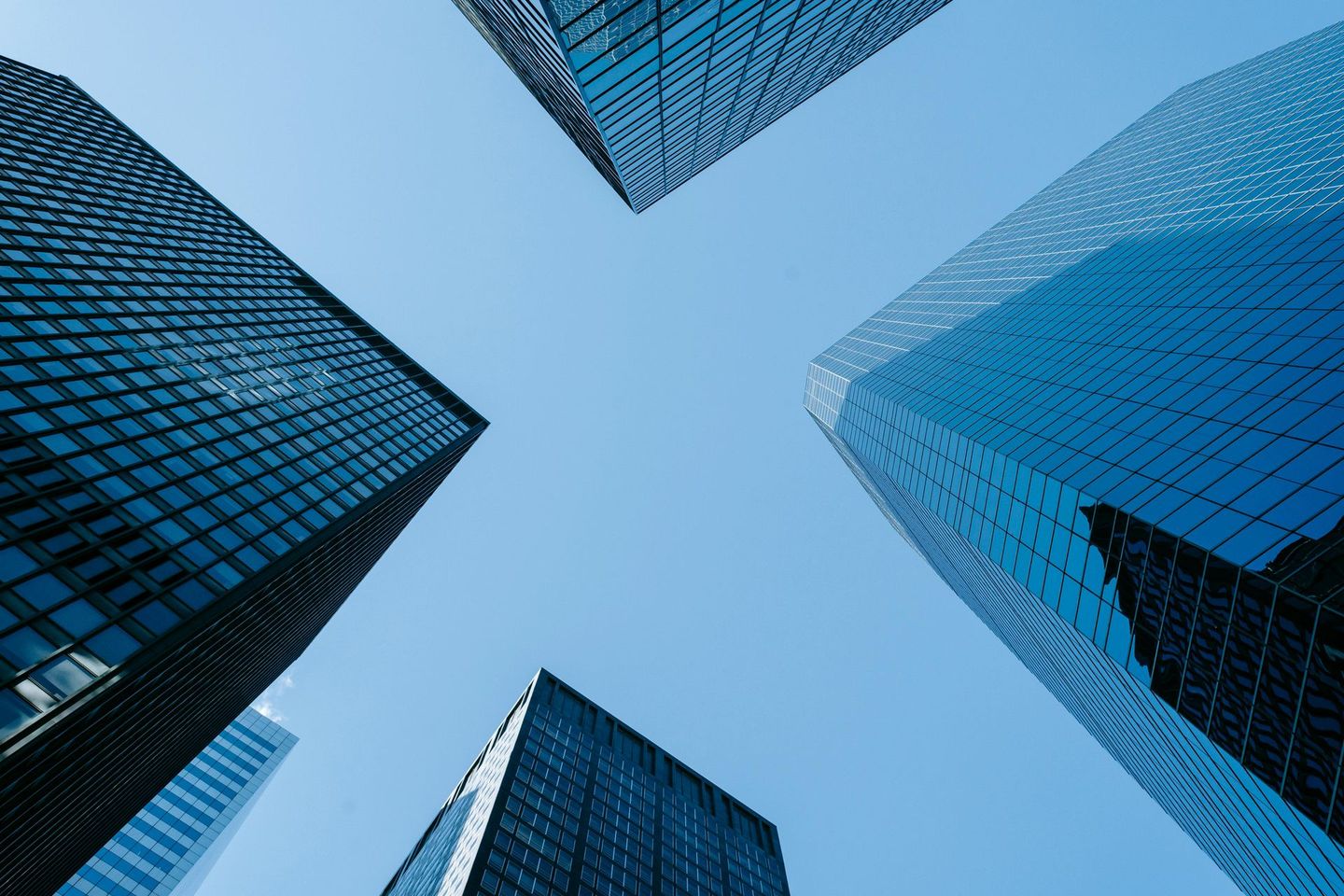 Skyscrapers against a bright blue sky, viewed from a low angle.