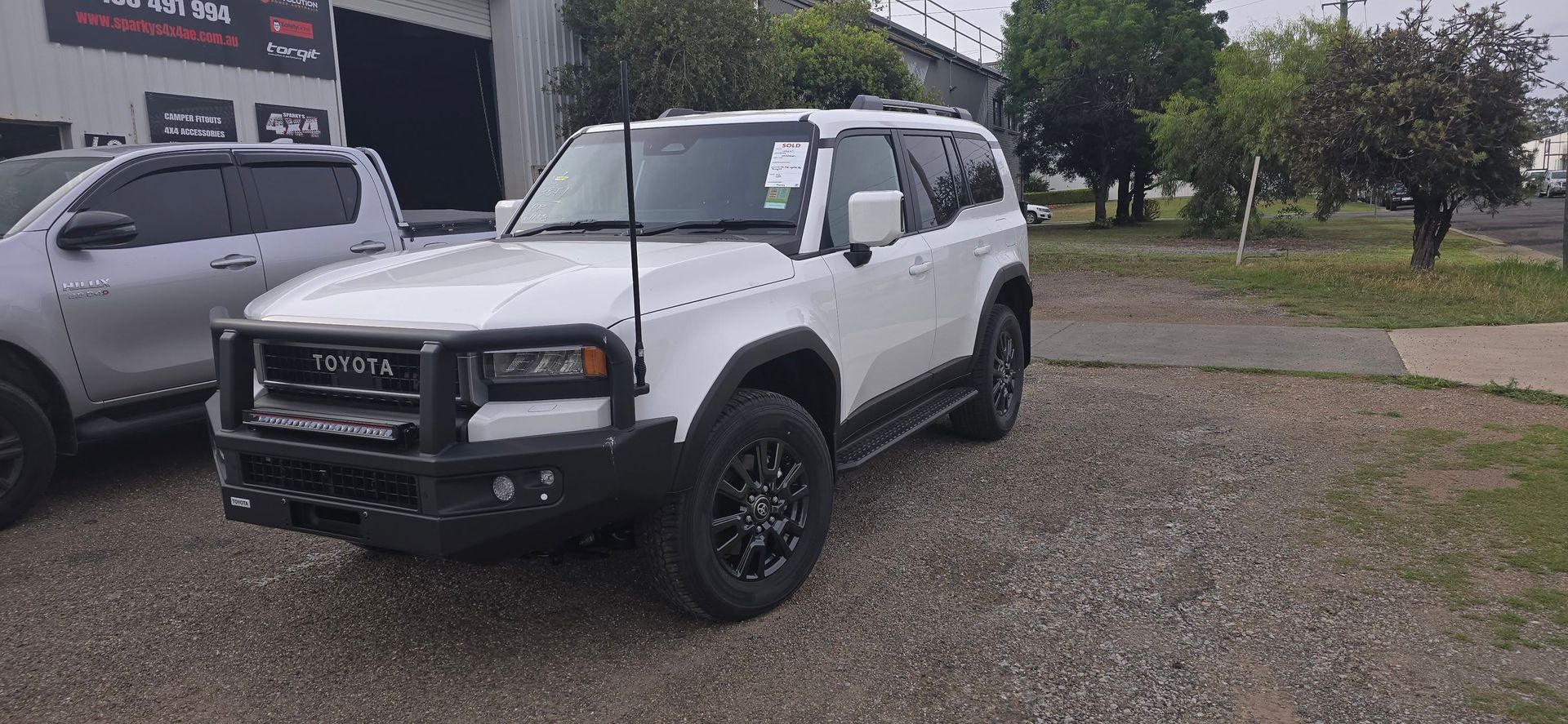 White Off-Road Vehicle Parked on Gravel. Black Grill Guard and Wheels — Sparky's 4x4 In Taminda, NSW