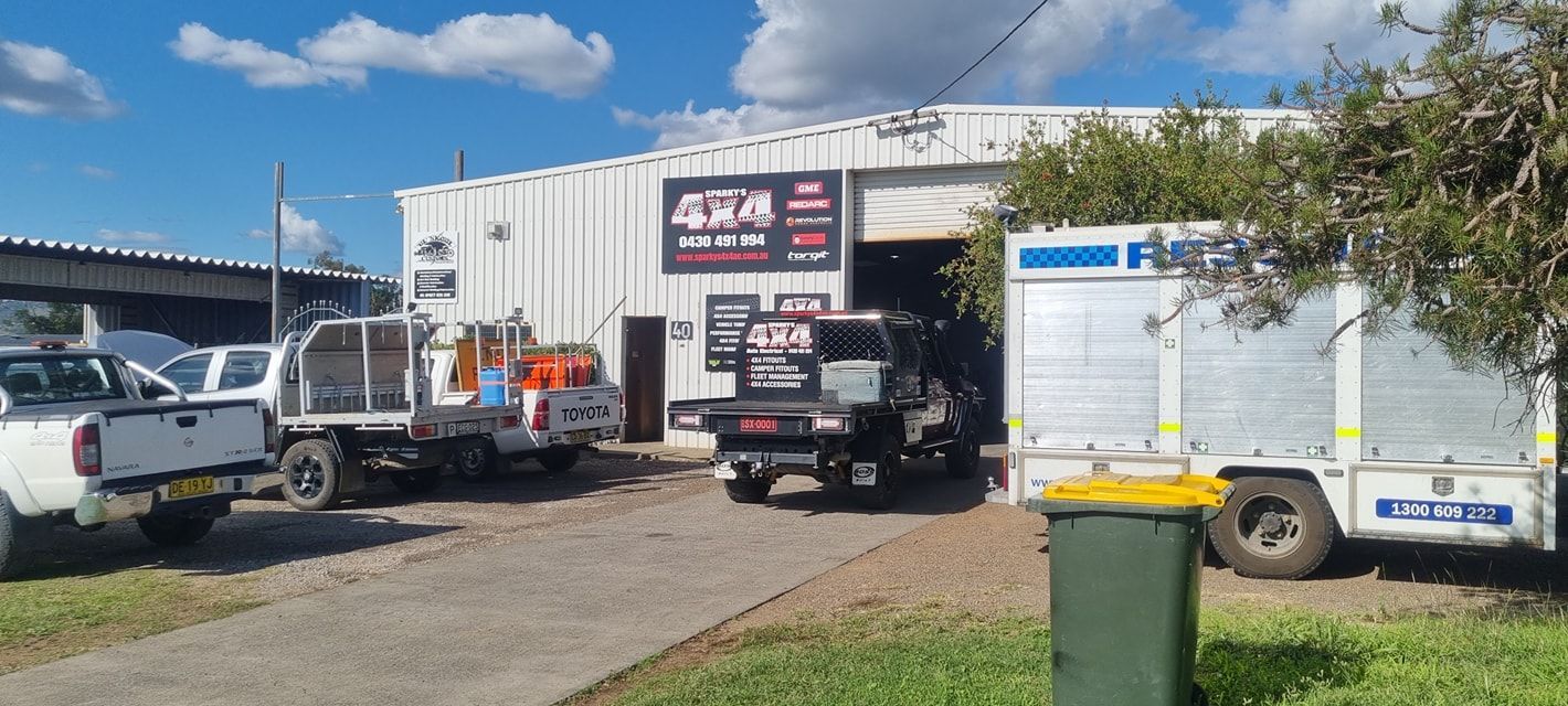 Exterior of A Workshop with Several Trucks Parked Outside, Sunny Day — Sparky's 4x4 In Taminda, NSW