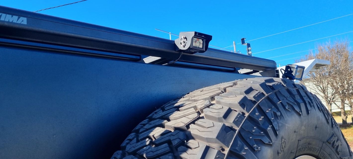 Black Vehicle with A Spare Tire, Rack with A Light, Against a Clear Blue Sky — Sparky's 4x4 In Armidale, NSW
