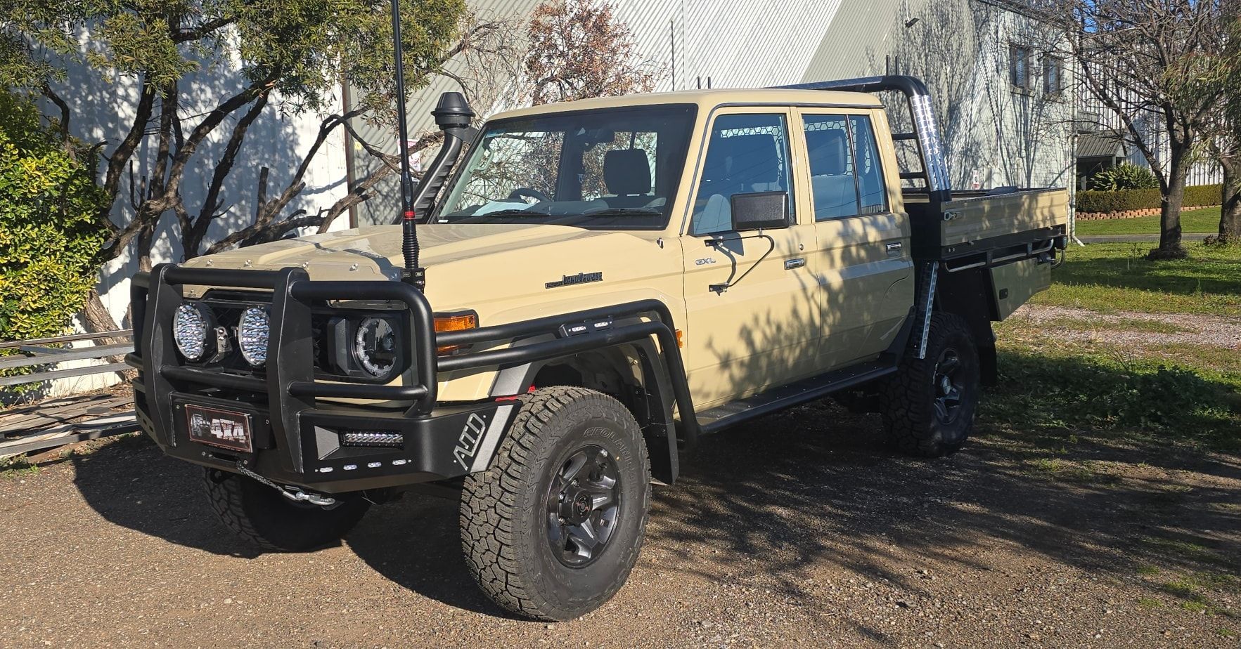 Tan Toyota Land Cruiser with Bull Bar and Black Wheels Parked on Driveway — Sparky's 4x4 In Taminda, NSW
