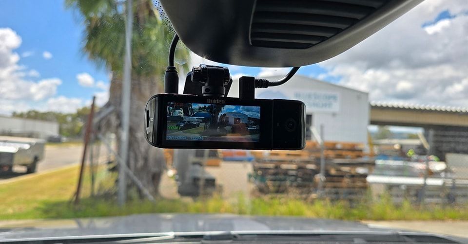A Dash Cam is Hanging From the Rear View Mirror of a Car — Sparky's 4x4 In Taminda, NSW