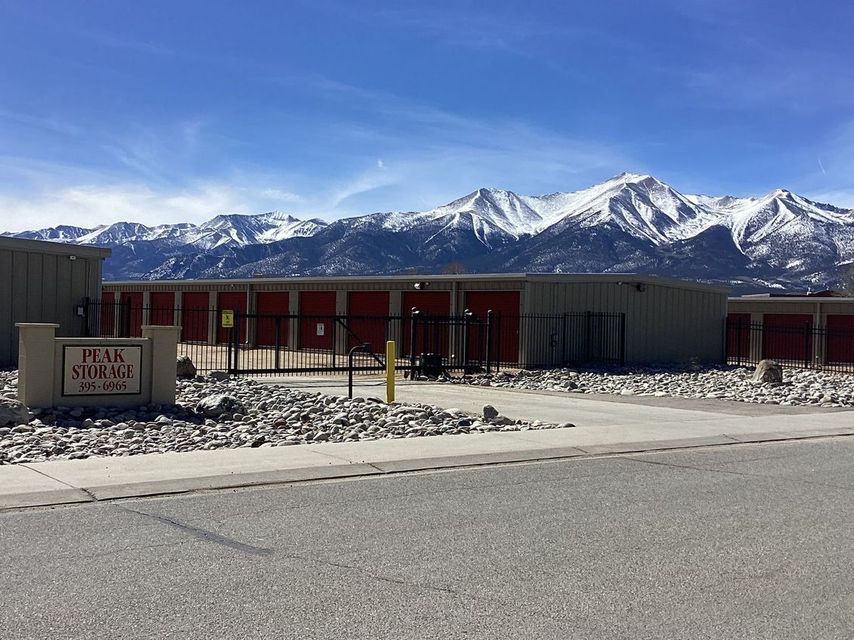 Low building with red accents in snowy landscape, mountains under a clear blue sky.