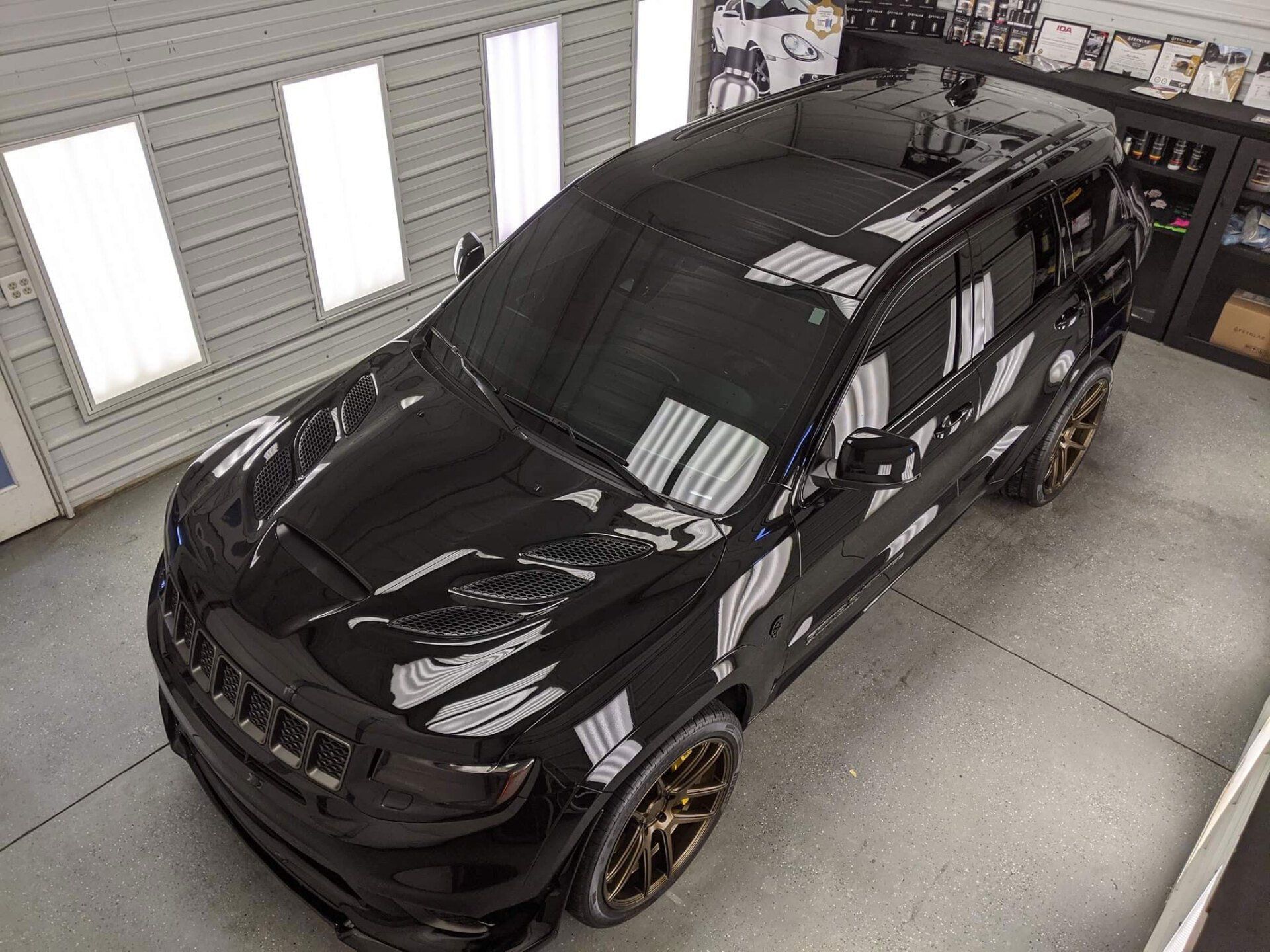 A black jeep grand cherokee is parked in a garage.
