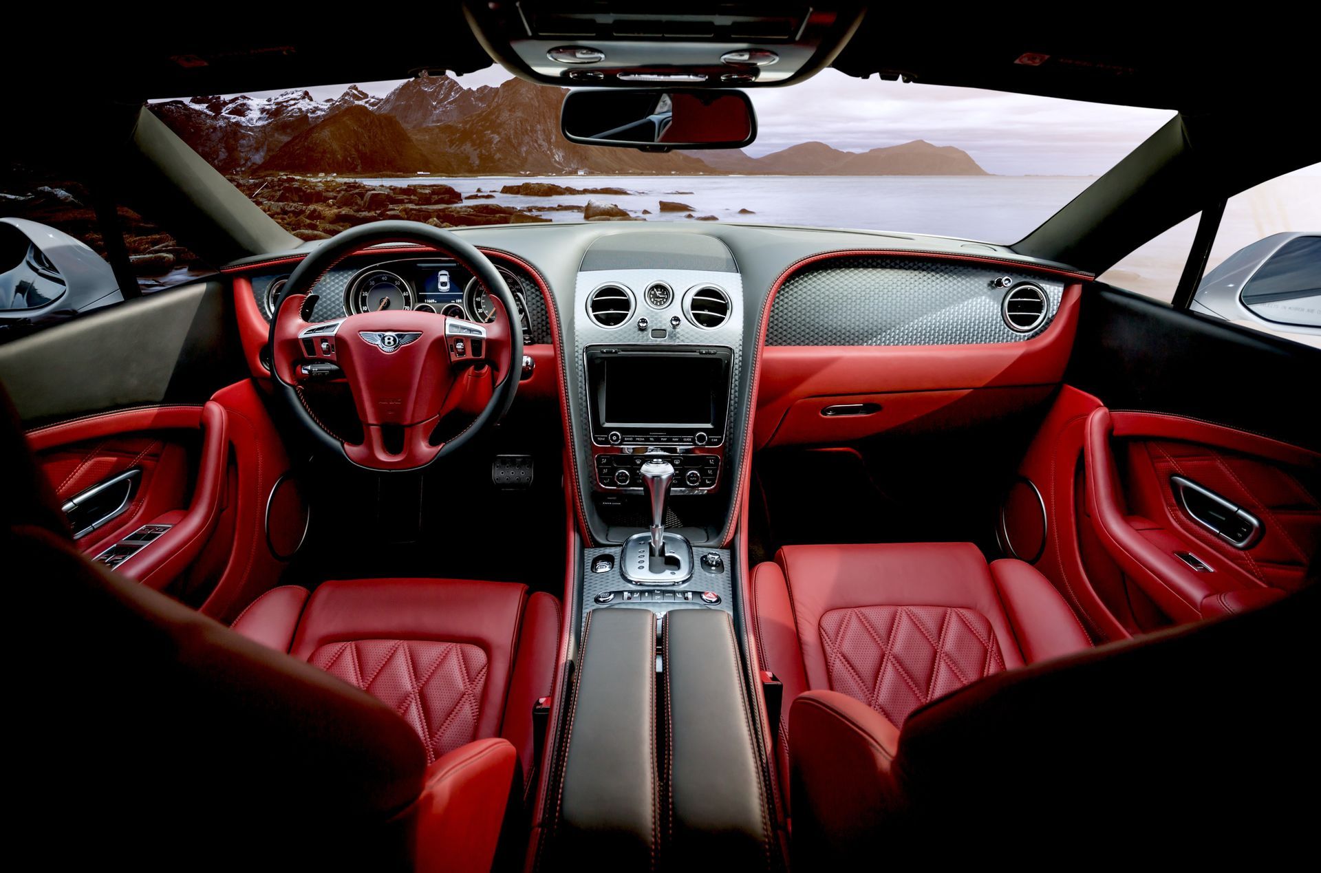 The interior of a car with red seats and a steering wheel