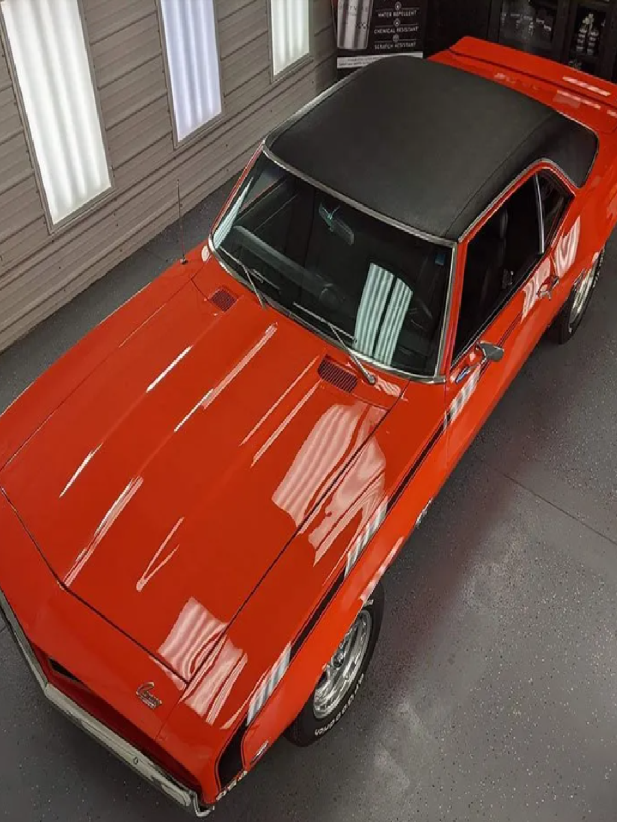 Overhead view of an orange car ready for ceramic coating.