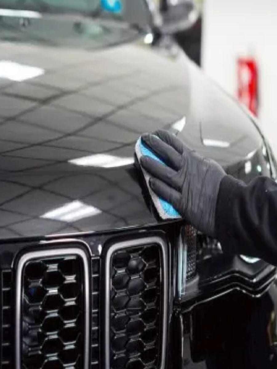 Applying ceramic coating to a black vehicle’s front grill.