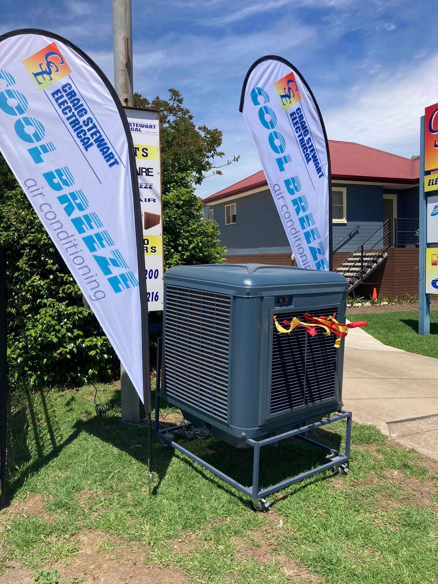 Cool Breeze Air Conditioner on Wheels With Signage in Front of Building — Craig Stewart Electrical in East Wagga Wagga, NSW