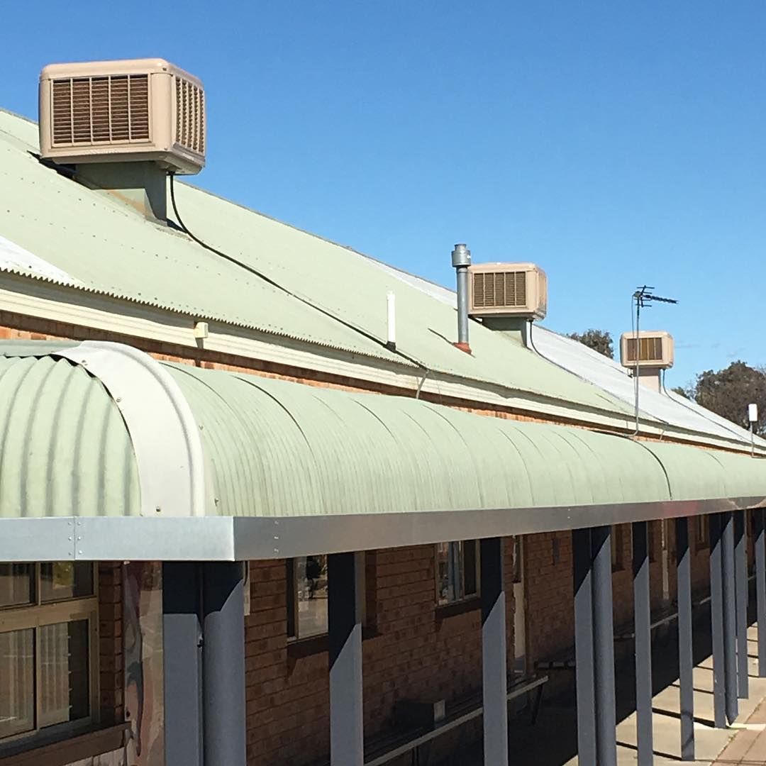 Building With Corrugated Metal Roof, Awnings, and Air Conditioning Units — Craig Stewart Electrical in East Wagga Wagga, NSW
