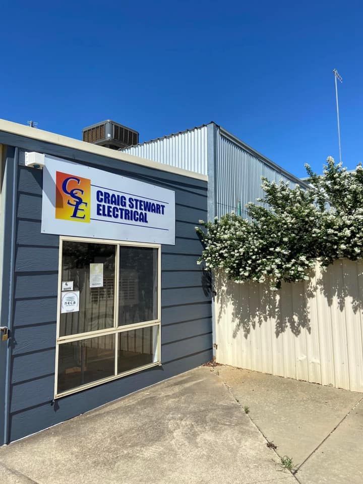 Exterior of Craig Stewart Electrical office with blue siding, sign, door, and white fence under a clear sky — Craig Stewart Electrical in East Wagga Wagga, NSW