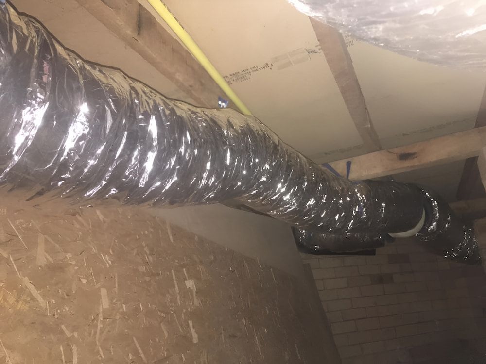 Flexible Silver Ductwork Runs Across a Wooden Attic Space — Craig Stewart Electrical in East Wagga Wagga, NSW