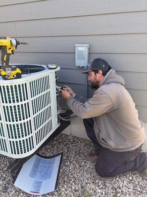 A man is fixing an air conditioner on the ceiling.
