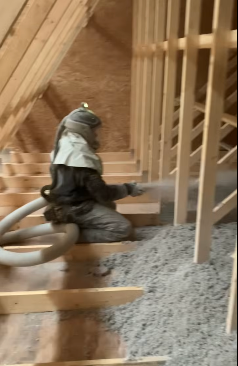 Blown-in insulation being installed into a wall cavity
