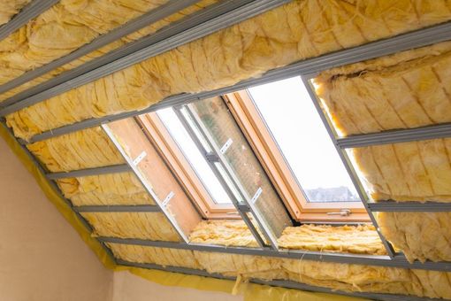 Batt insulation installed between roof rafters near a skylight in a home