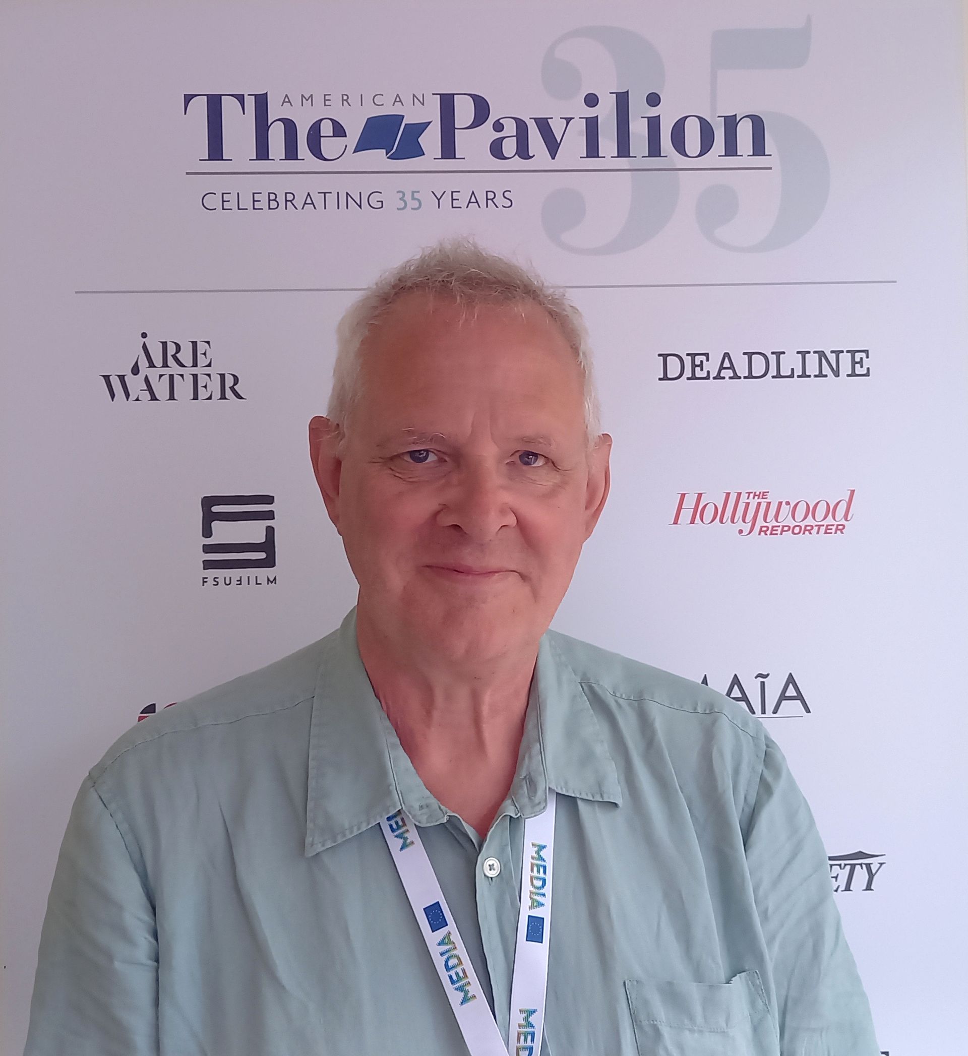 Thom Palmen in front of The American Pavilion poster Cannes Film Festival 2023