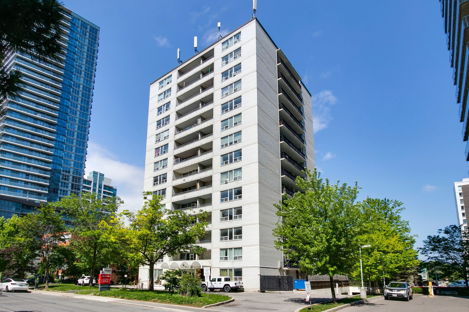 A tall building with a lot of windows is in the middle of a city.
