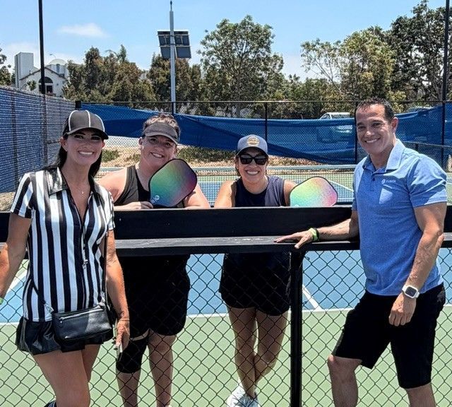 PWI 2026 Pickleball Tournament - 4 adults standing on the pickleball court. Two have rackets