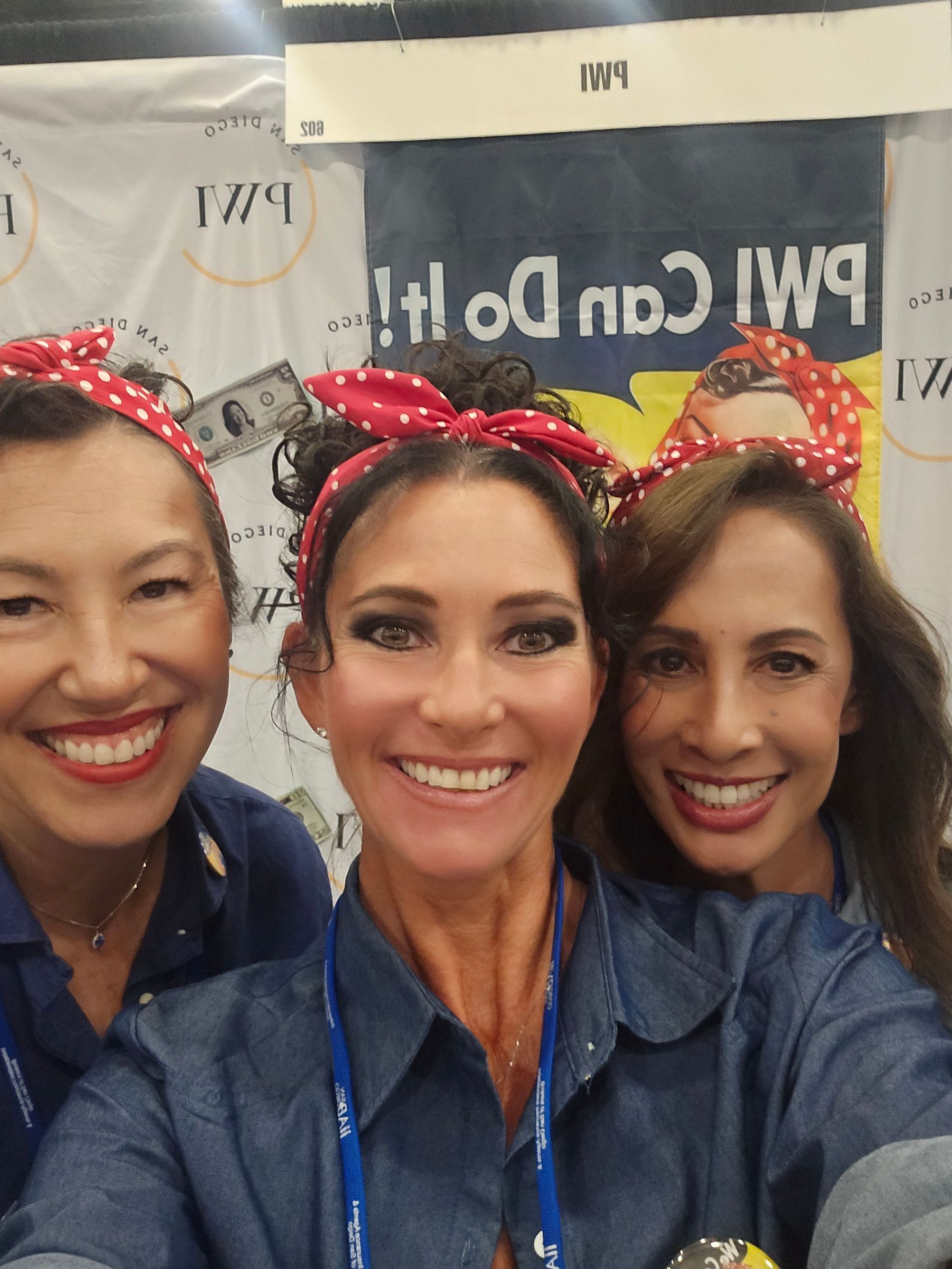Three women with red polka dot bandanas in their hair.