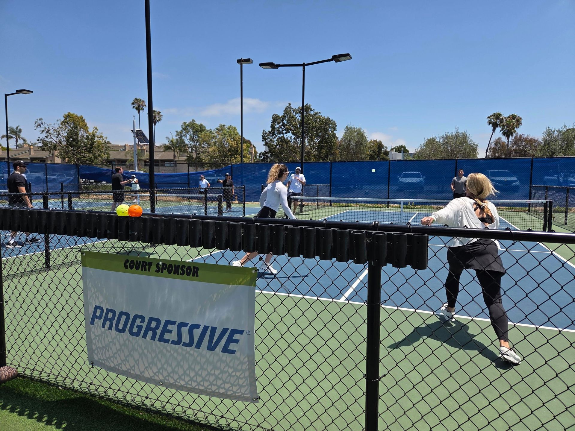 PWI 2026 Pickleball Tournament - playing pickleball on a court sponsored by Progressive