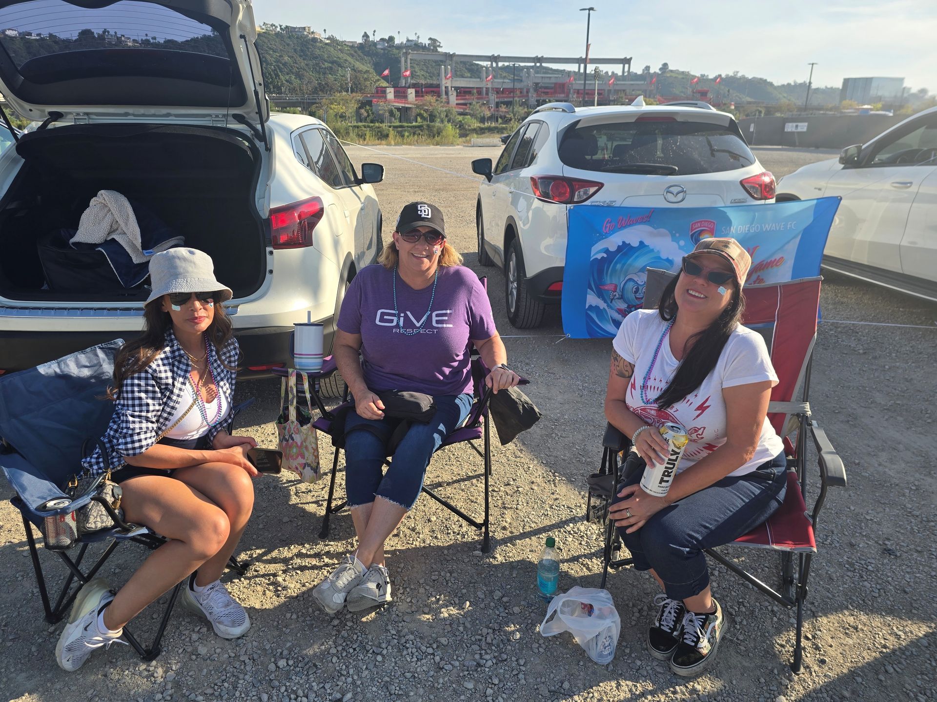 2026 Waves Soccer Game and Tailgate - 3 members sitting in the parking lot for the tailgate