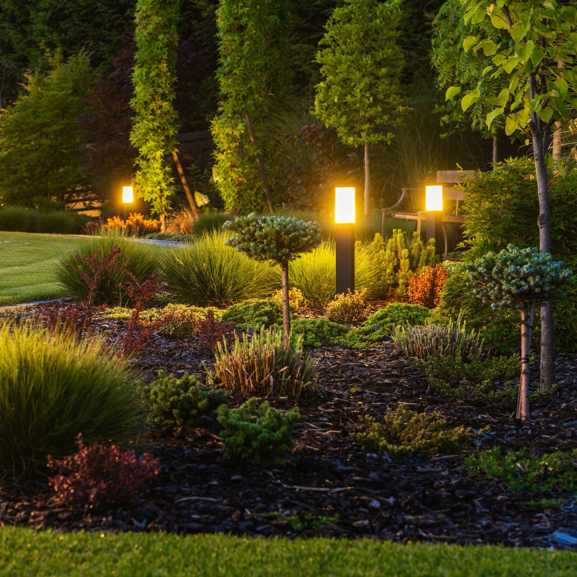 The house is lit up at night and has a large driveway.