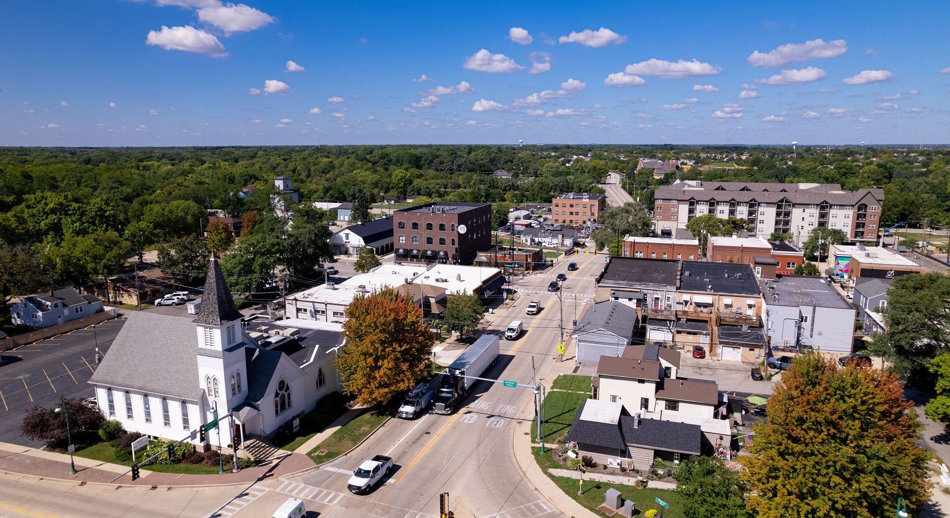 An aerial view of a small town with a church and a clock tower. Oswego Illinois