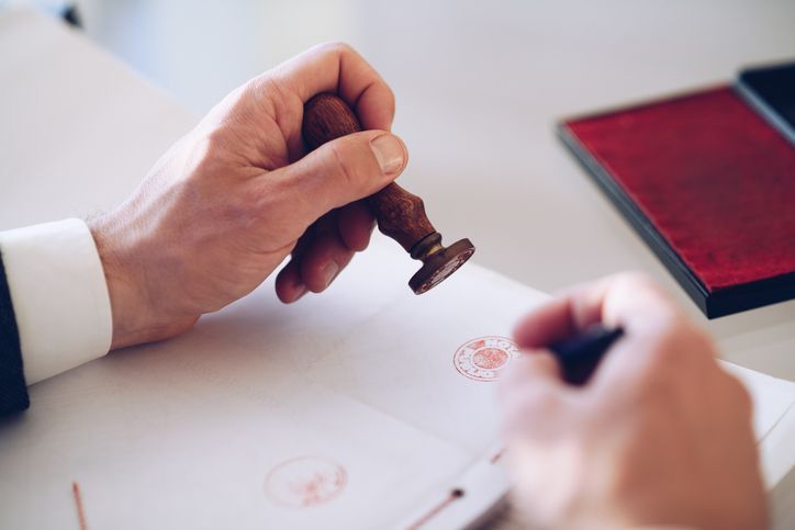 Una persona está sellando un documento con un sello de cera.