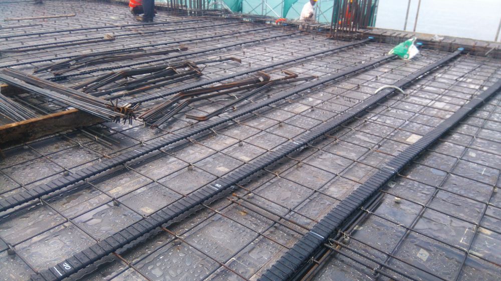 A construction site with a lot of steel bars on the ground.