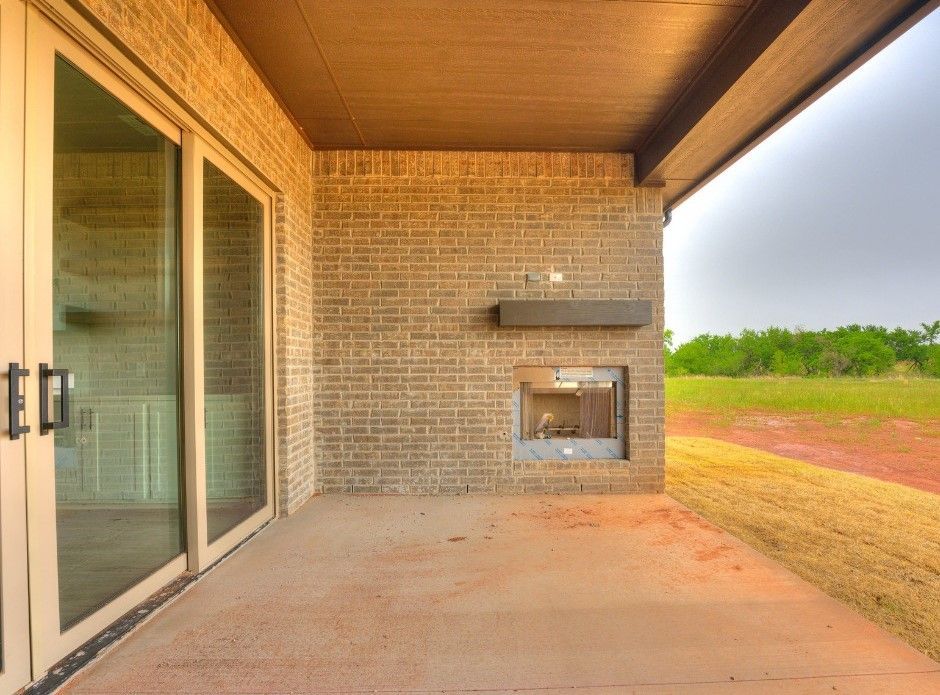 A patio with a fireplace and sliding glass doors