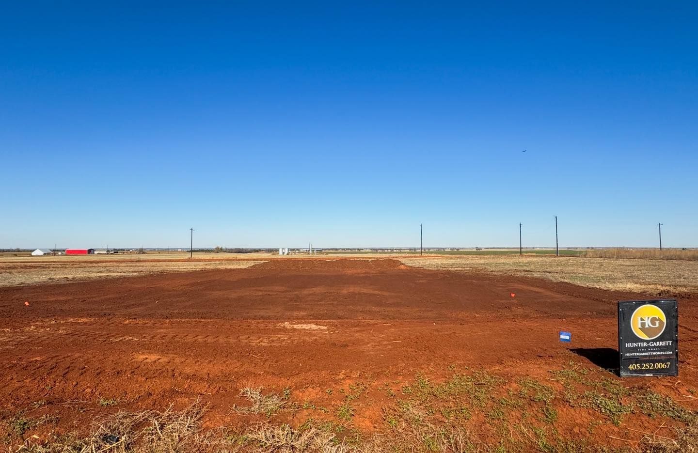 there is a sign in the middle of a dirt field