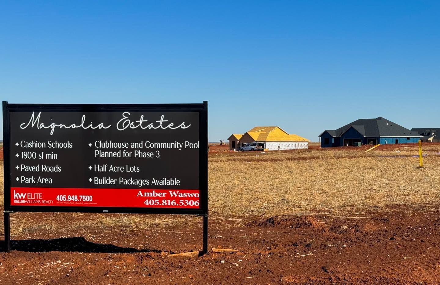 a sign for magnolia estates is sitting in the middle of a dirt field