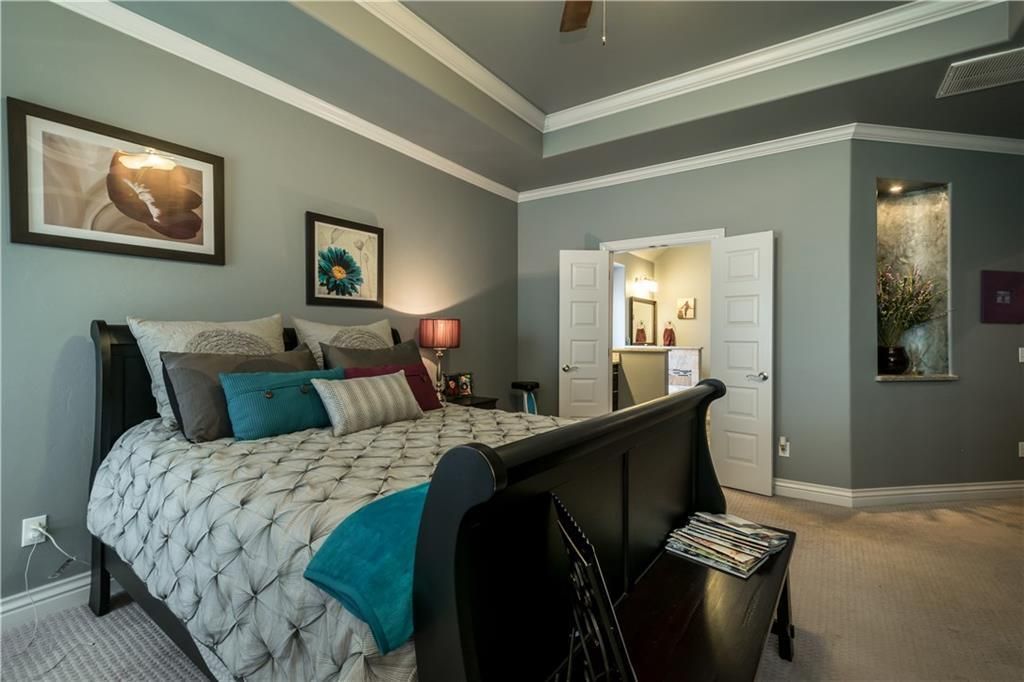 a bedroom with a sleigh bed and a ceiling fan