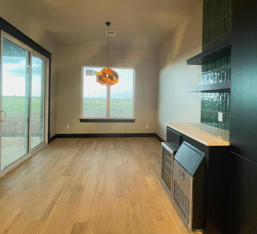 an empty room with hardwood floors and a sliding glass door