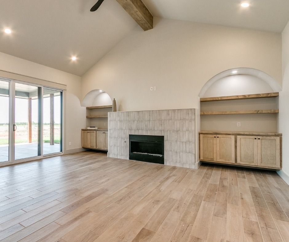 an empty living room with hardwood floors and a fireplace