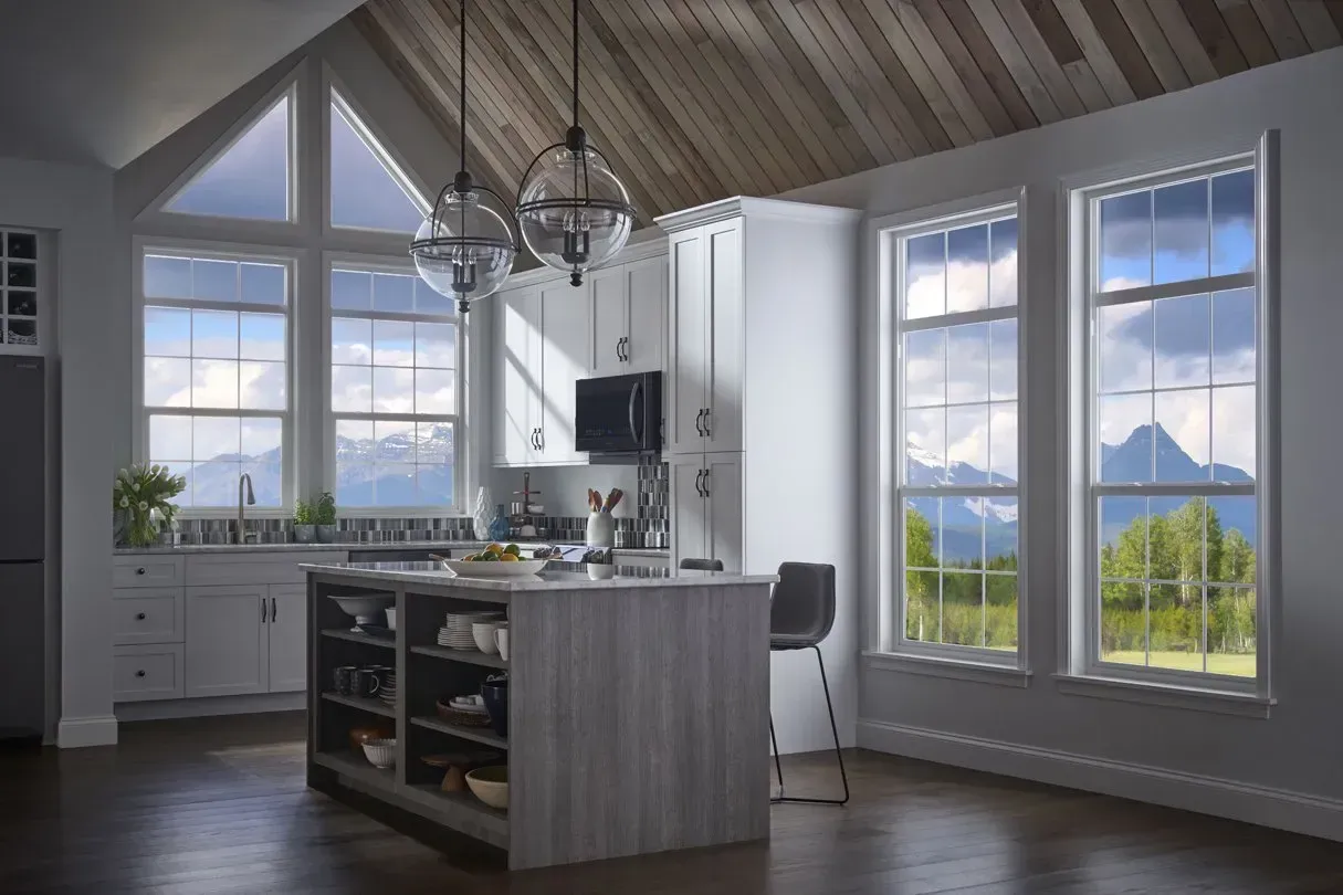 A kitchen with a lot of windows and a wooden ceiling.