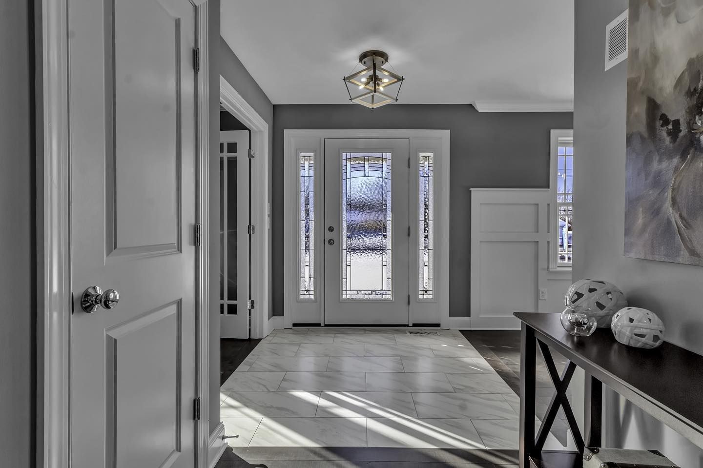 A hallway in a house with a table and a painting on the wall.