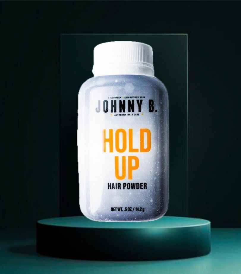 Johnny B. Hold Up hair powder bottle on a teal pedestal against a dark background