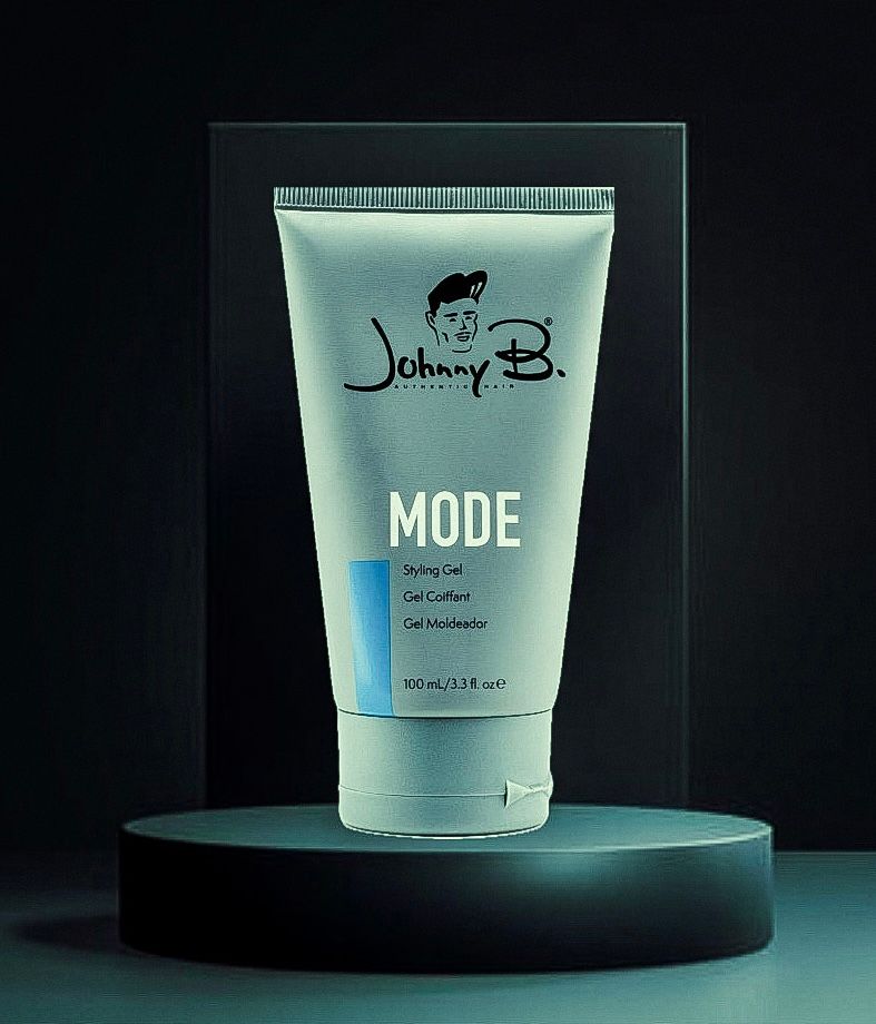 Johnnie B. Mode skincare tube on a dark pedestal against a black background.
