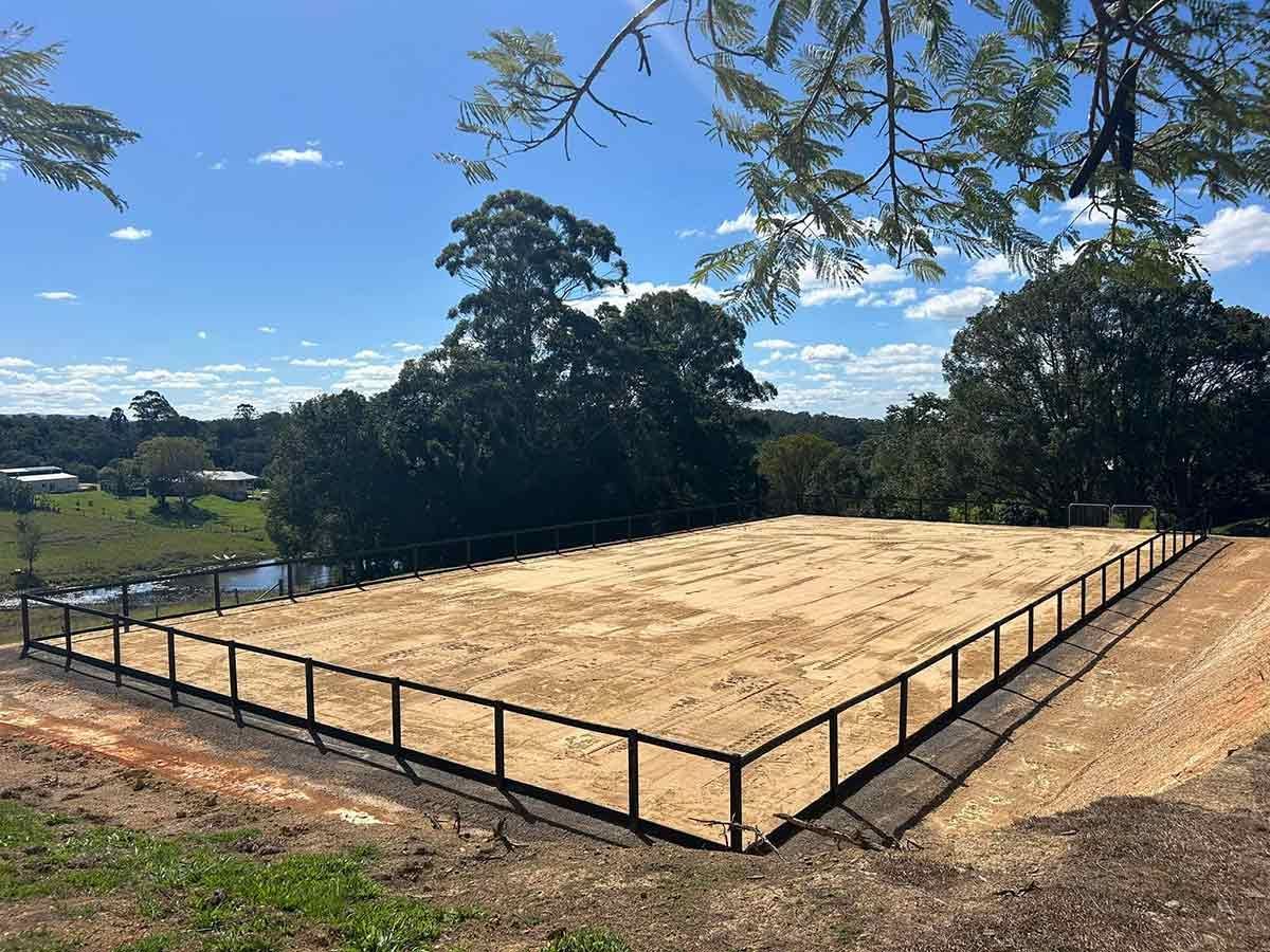 A Large Dirt Field With a Fence Around It and Trees in the Background — A2Z Property Services In Kybong, QLD