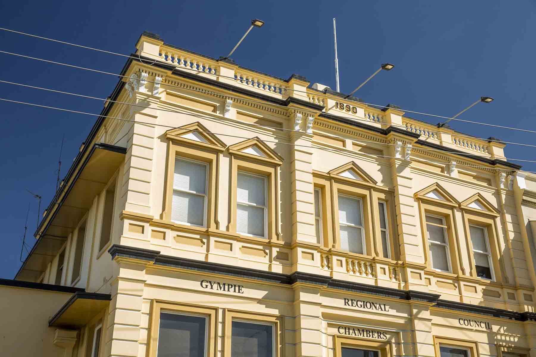 A Large Yellow Building With A Blue Sky In The Background — A2Z Property Services In Widgee, QLD